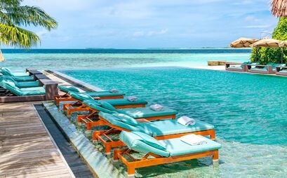 Maldives resort infinity pool with lounges